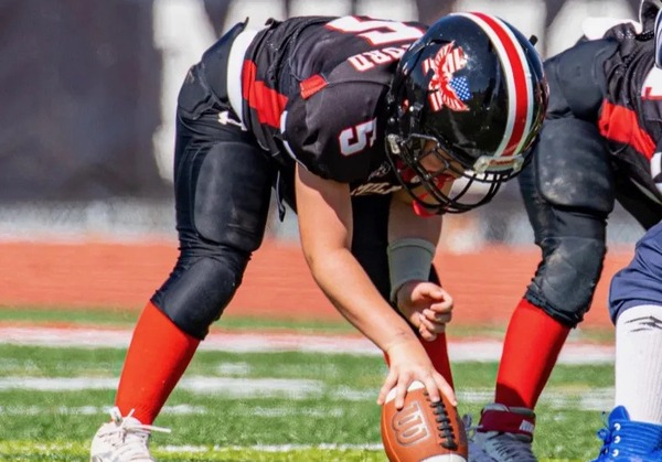 A high school football player preparing to snap the ball